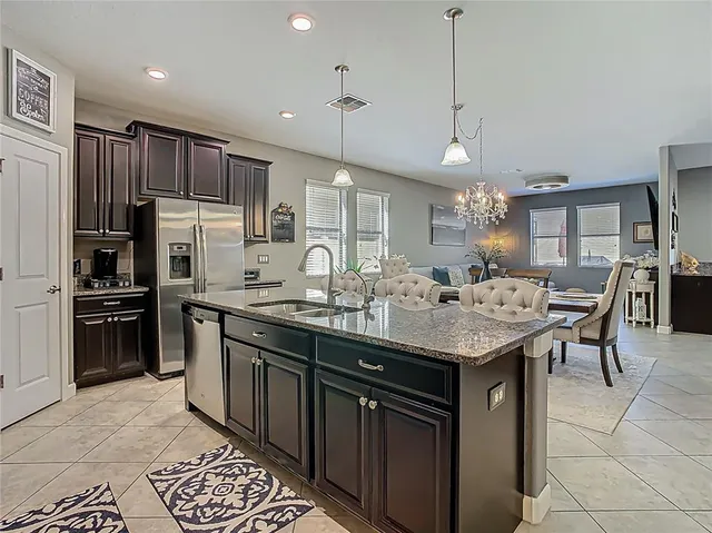 a kitchen with granite countertop cabinets stainless steel appliances and a dining table