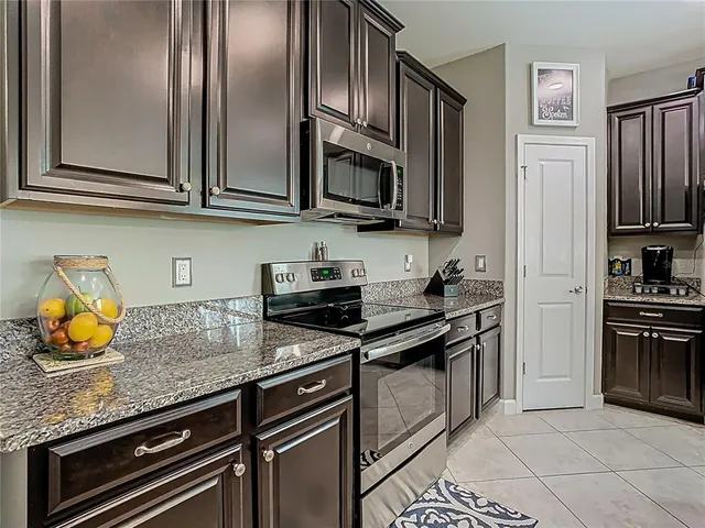 a kitchen with stainless steel appliances granite countertop a stove a sink and a microwave