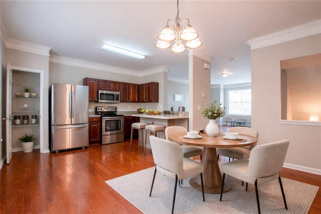 6764 Blackstone Place, Unit 6 Mableton, GA 30126 - Photo 1 of 5 a kitchen with stainless steel appliances a dining table chairs refrigerator and microwave