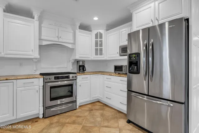 a kitchen with stainless steel appliances granite countertop a refrigerator sink and stove