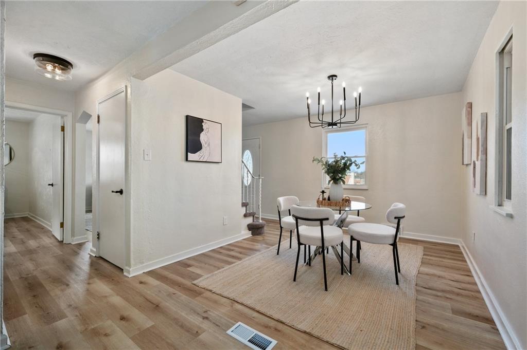3593 Middleboro Road Pittsburgh, PA 15234 - Photo 7 of 20 a dining room with wooden floor a chandelier a wooden table and chairs