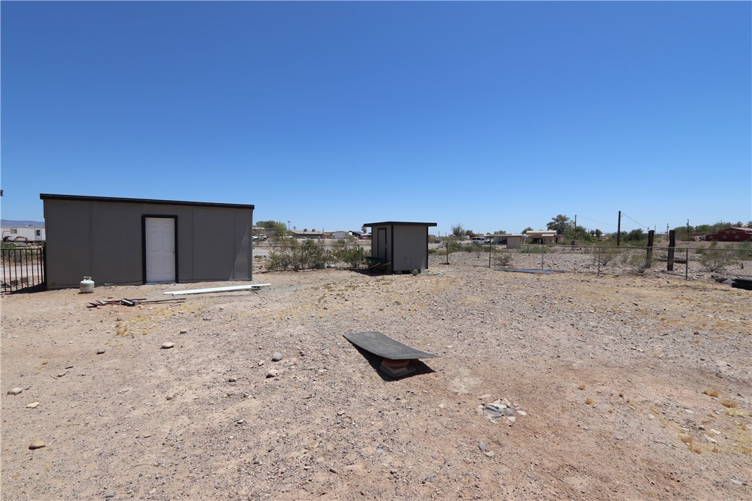 1290 Hammer Road Fort Mohave, AZ 86426 - Photo 15 of 16 Expansive gravel lot featuring a workshop, and covered well outbuildings and partial perimeter fencing.