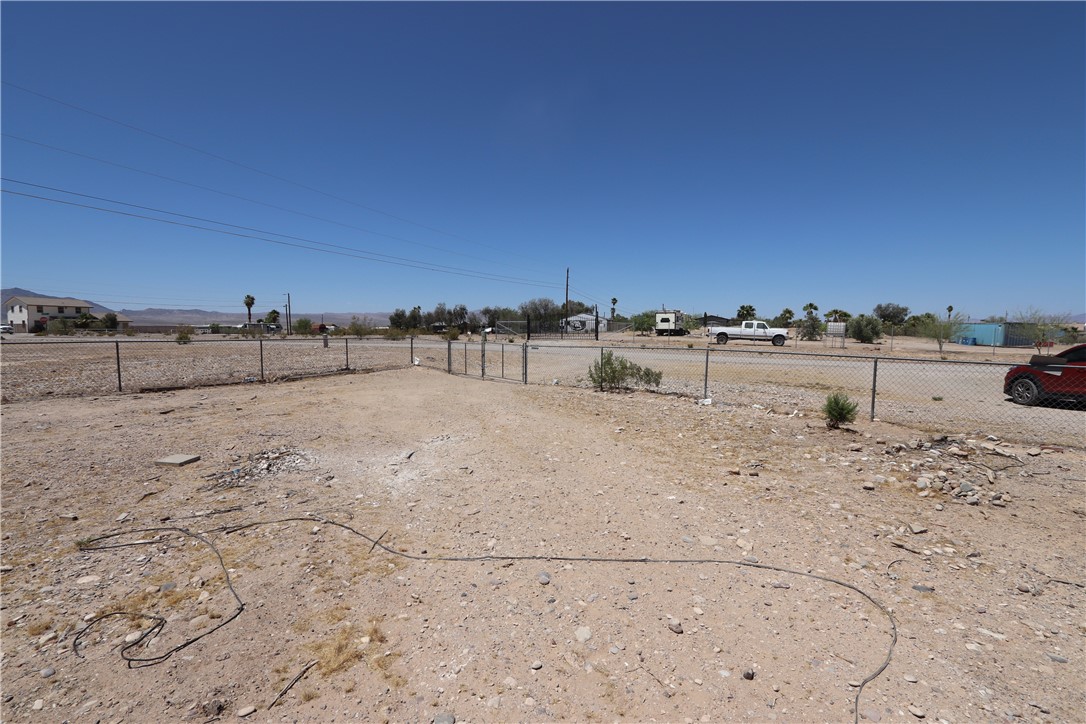 1290 Hammer Road Fort Mohave, AZ 86426 - Photo 16 of 16 Expansive gravel lot featuring a double gate chain-link fence. Distant mountain ranges.