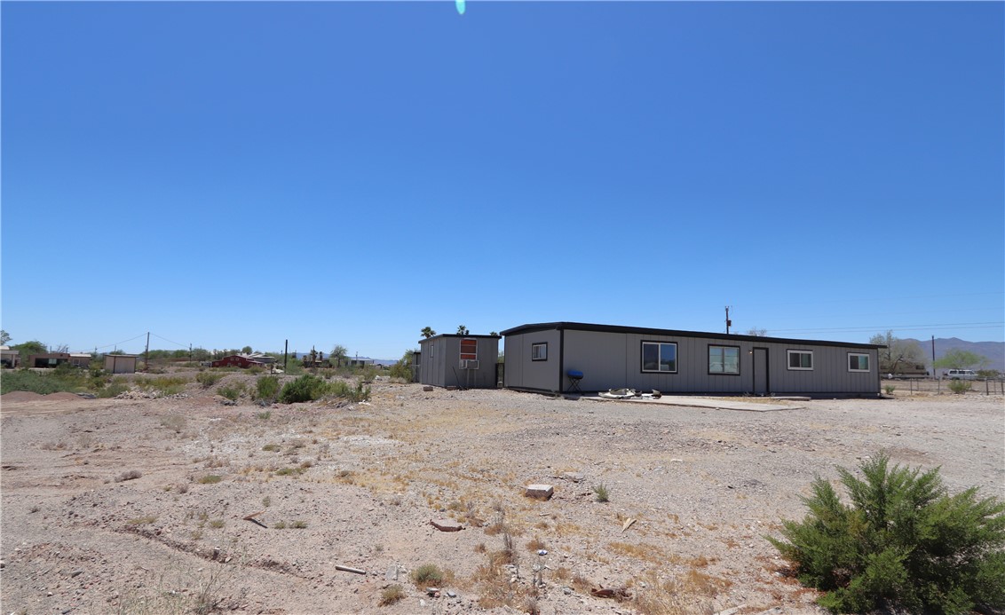 1290 Hammer Road Fort Mohave, AZ 86426 - Photo 2 of 16 Single-story residence featuring a gray exterior siding and a black trim roofline.