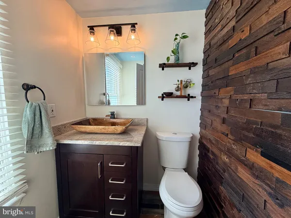 a bathroom with a granite countertop toilet sink and mirror