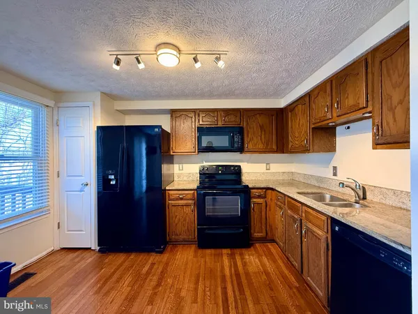 a kitchen with stainless steel appliances granite countertop a stove cabinets and refrigerator