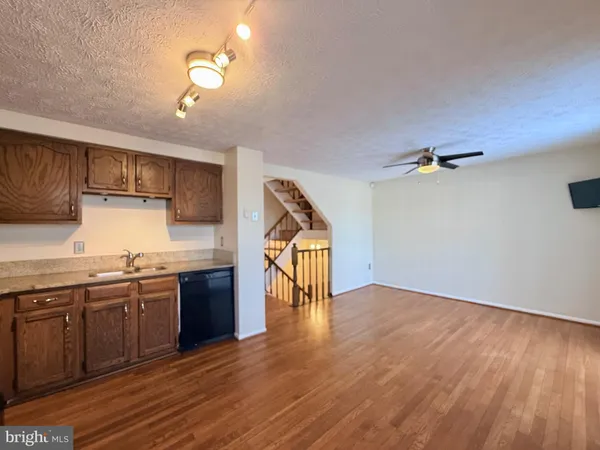 a kitchen with stainless steel appliances granite countertop a sink cabinets and wooden floor