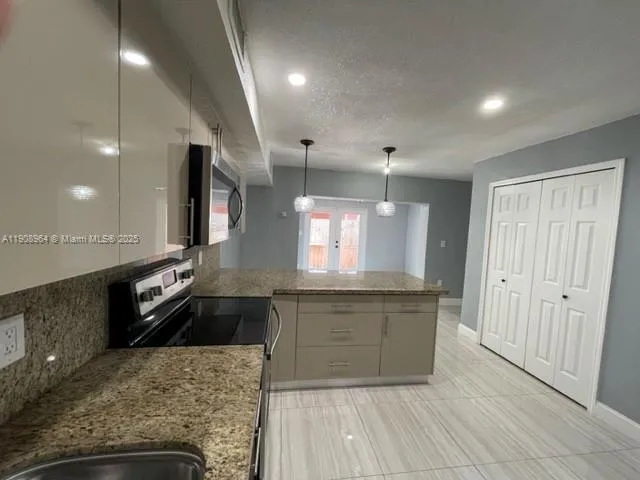 a large kitchen with granite countertop a large counter top and sink
