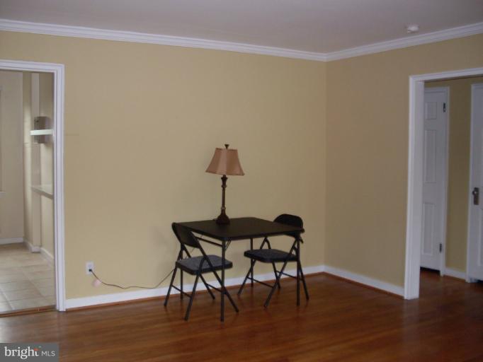 205 East Glebe Road, Unit 6205E Alexandria, VA 22305 - Photo 5 of 13 a view of a room with wooden floor table and chairs