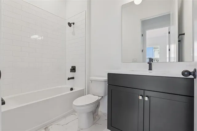 a bathroom with a sink a toilet a mirror and shower