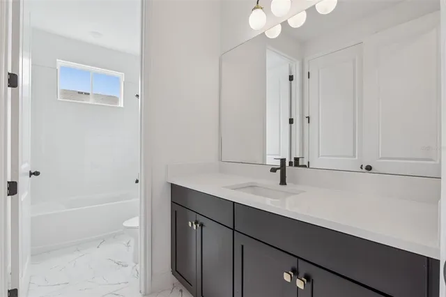 a bathroom with a sink vanity and mirror