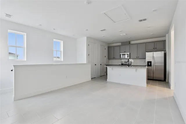 a view of kitchen with stainless steel appliances refrigerator oven and cabinets