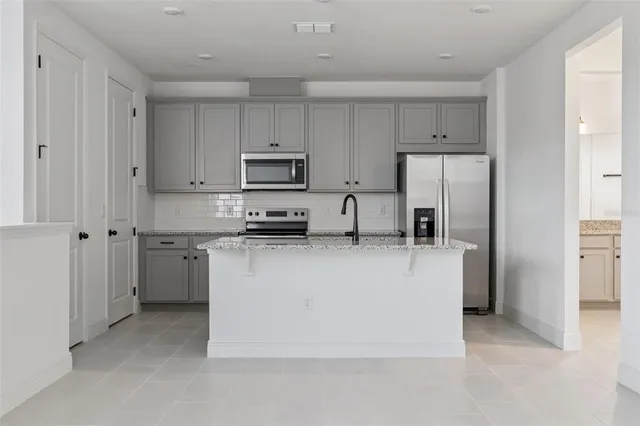 a kitchen with stainless steel appliances a refrigerator sink and cabinets