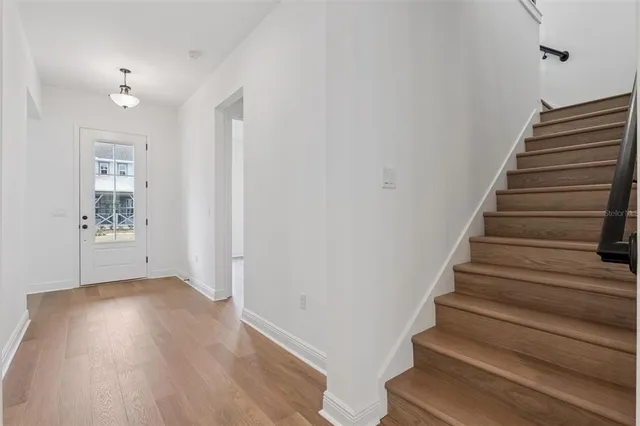 a view of entryway and hall with wooden floor