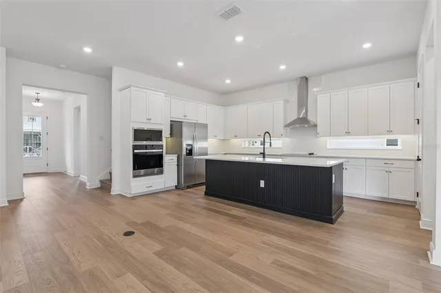 a kitchen with stainless steel appliances kitchen island granite countertop a sink a stove and cabinets