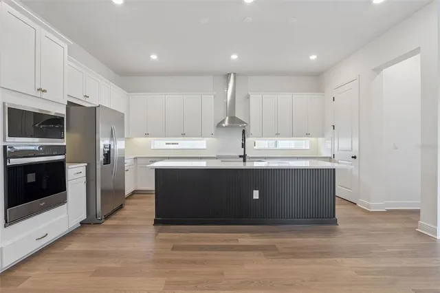 a kitchen with kitchen island granite countertop a sink stainless steel appliances and white cabinets