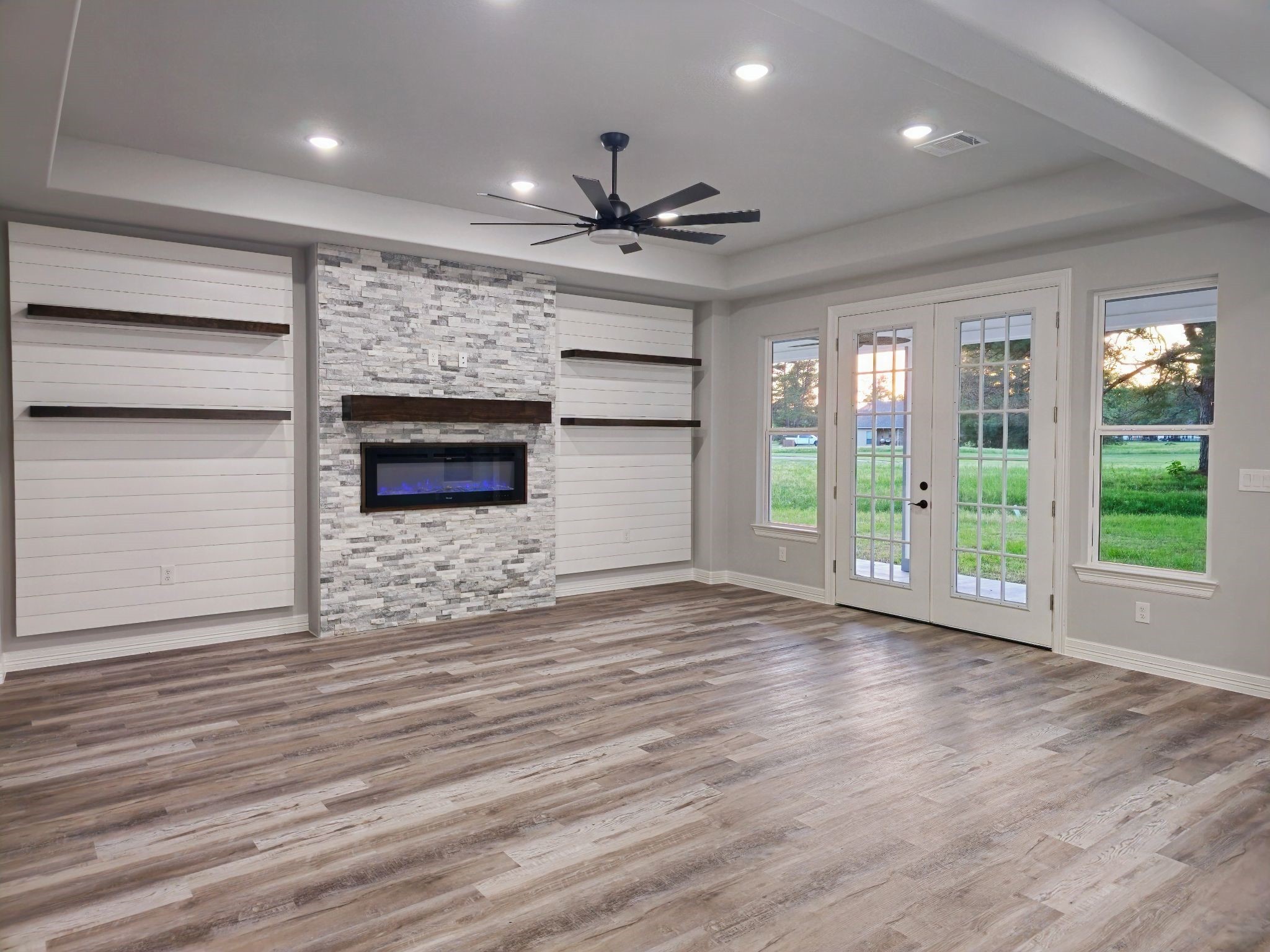 20 Lazy Springs Trinity, TX 75862 - Photo 4 of 37 Living room with a stone fireplace, built-in floating shelving, over shiplap accent wall.