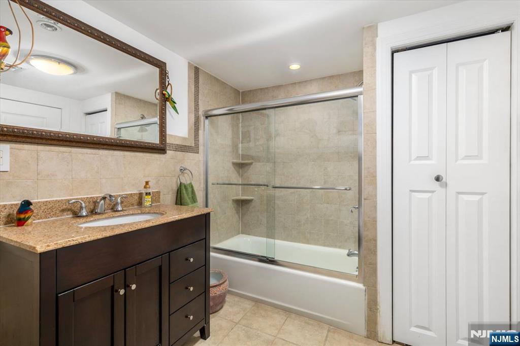 65 Lincoln Avenue Rutherford, NJ 07070 - Photo 32 of 39 a bathroom with a tub sink vanity granite and shower