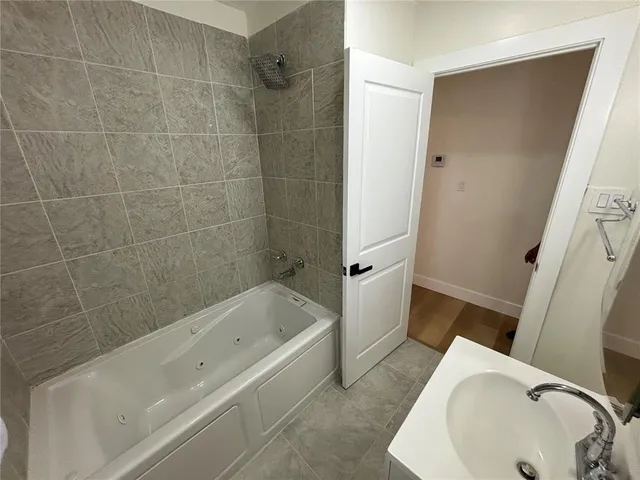 a bathroom with a tub a sink and toilet