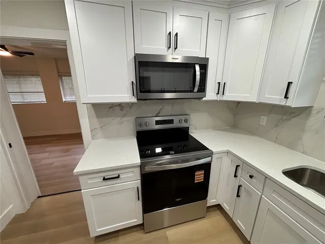 a kitchen with stainless steel appliances white cabinets and a stove