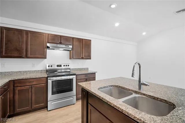 a kitchen with a sink stove and cabinets