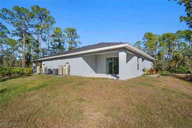 a front view of house with yard and trees in the background