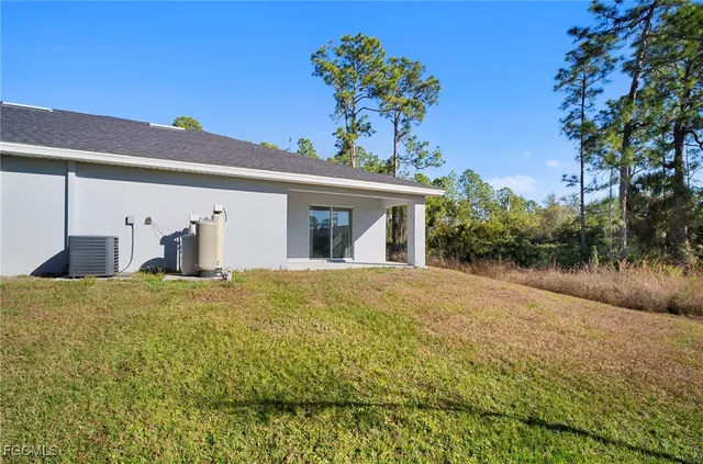 a view of a house with a backyard and a tree