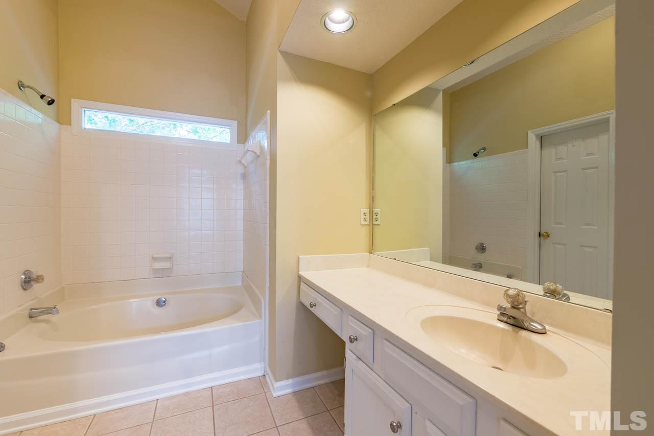 3608 Singleleaf Lane Raleigh, NC 27616 - Photo 9 of 23 a bathroom with a granite countertop sink and a bathtub