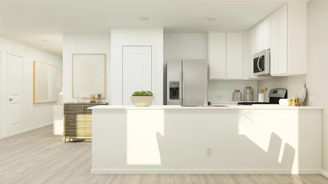 a kitchen with stainless steel appliances granite countertop a sink a stove and white cabinets with wooden floor