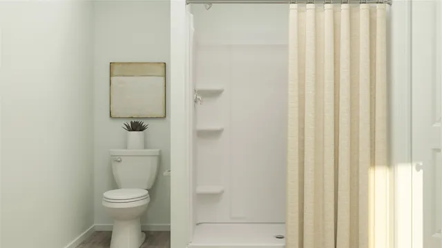a white toilet sitting next to a shower
