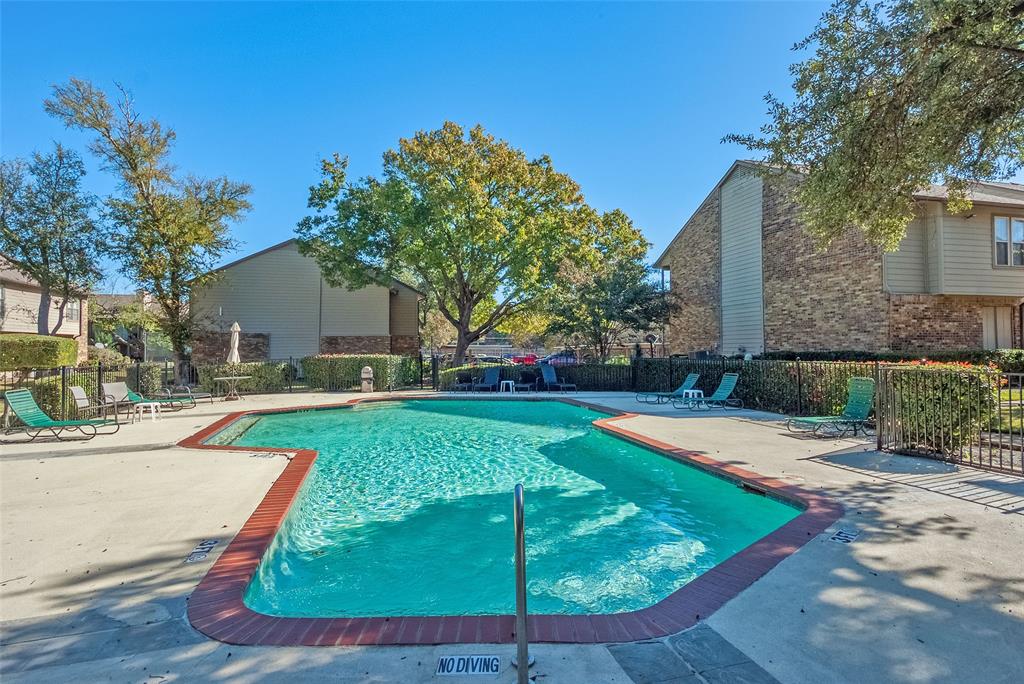 5300 Keller Springs Road, Unit 1048 Dallas, TX 75248 - Photo 32 of 38 A sparkling pool featuring sun loungers and lush landscaping, perfect for relaxation and leisure activities.