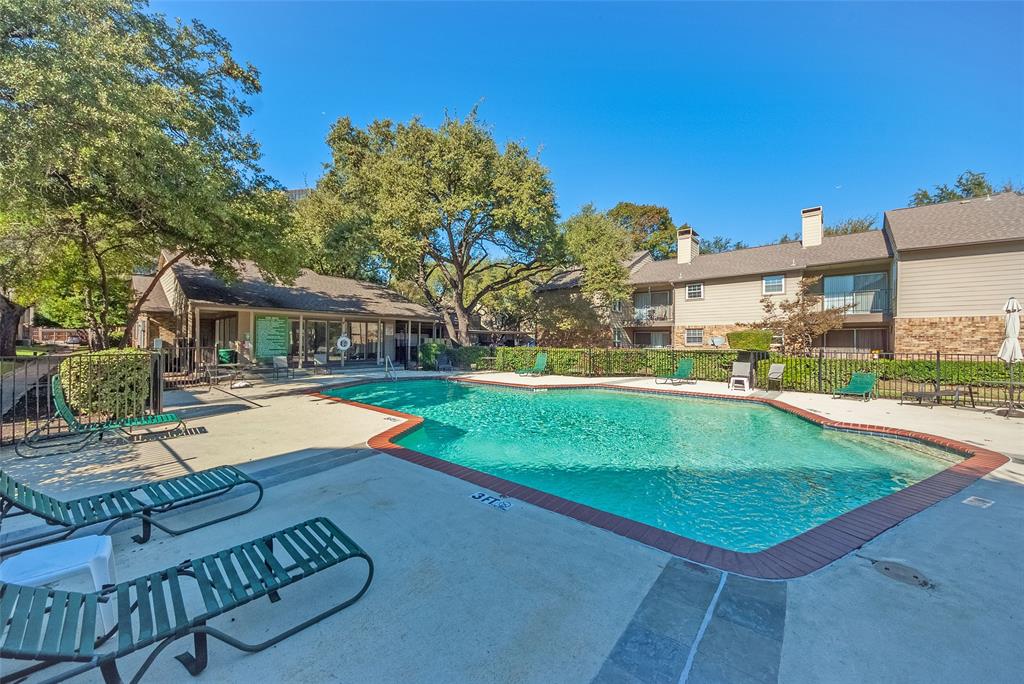 5300 Keller Springs Road, Unit 1048 Dallas, TX 75248 - Photo 33 of 38 A sparkling pool featuring sun loungers and lush landscaping, perfect for relaxation and leisure activities.