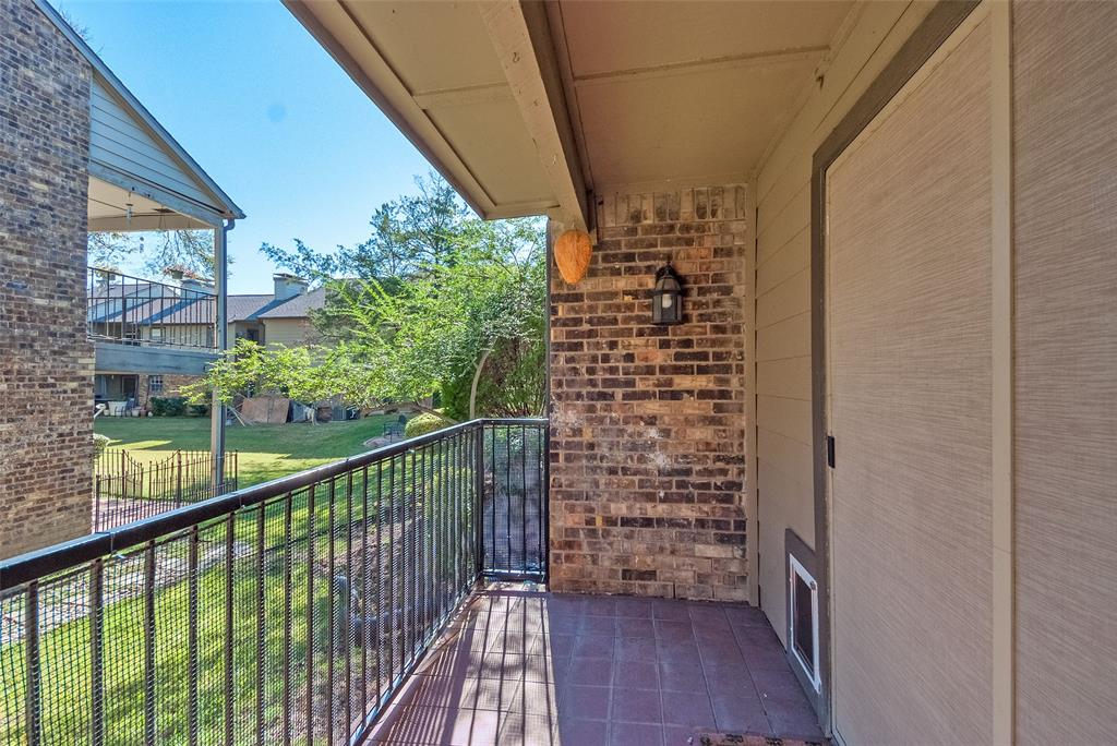 5300 Keller Springs Road, Unit 1048 Dallas, TX 75248 - Photo 37 of 38 A balcony with railing, offering a charming outdoor area for enjoying fresh air and scenery.