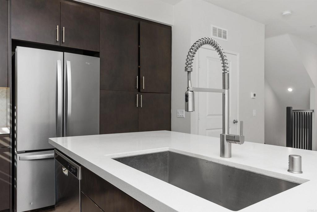 1309 Via Lucero Oceanside, CA 92056 - Photo 13 of 50 a kitchen with a refrigerator a sink and cabinets