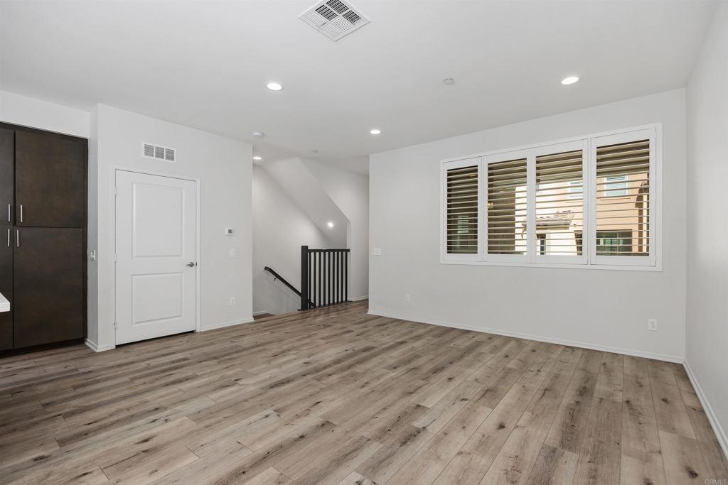 1309 Via Lucero Oceanside, CA 92056 - Photo 15 of 50 a view of an empty room with wooden floor and a window