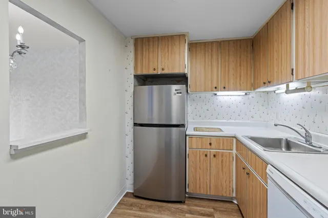 a kitchen with a refrigerator sink and cabinets