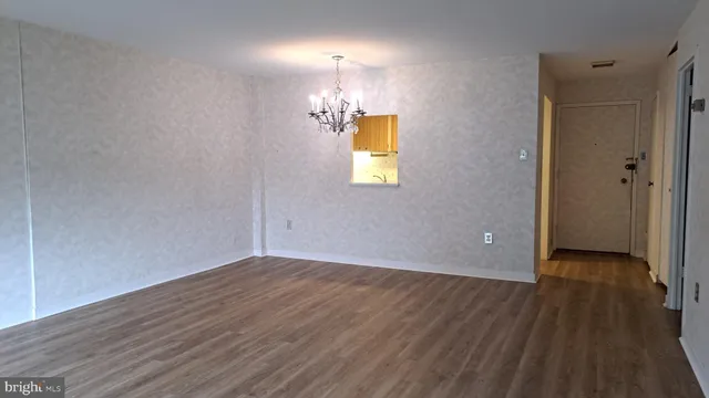 a view of empty room with wooden floor and window