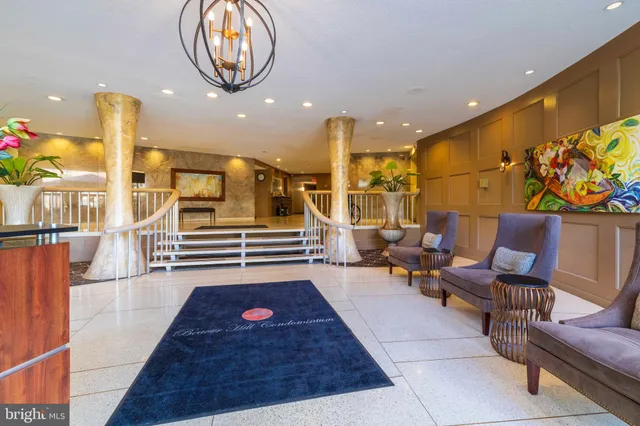 a living room with furniture a rug and kitchen view