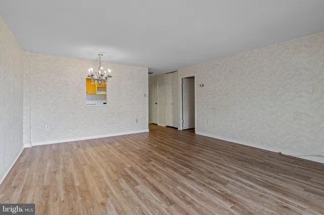 a view of empty room with wooden floor and fireplace