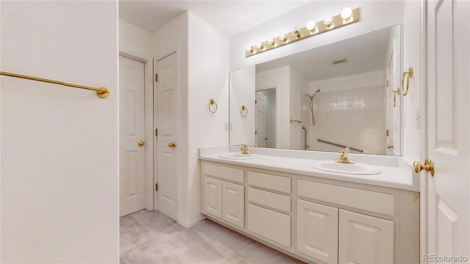 4367 Quail Street Wheat Ridge, CO 80033 - Photo 23 of 50 a bathroom with a double vanity sink mirror and