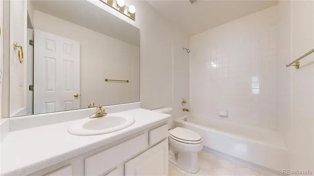 a bathroom with a granite countertop sink a toilet and shower