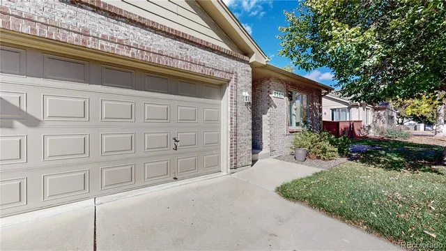 a view of a house with backyard and a tree