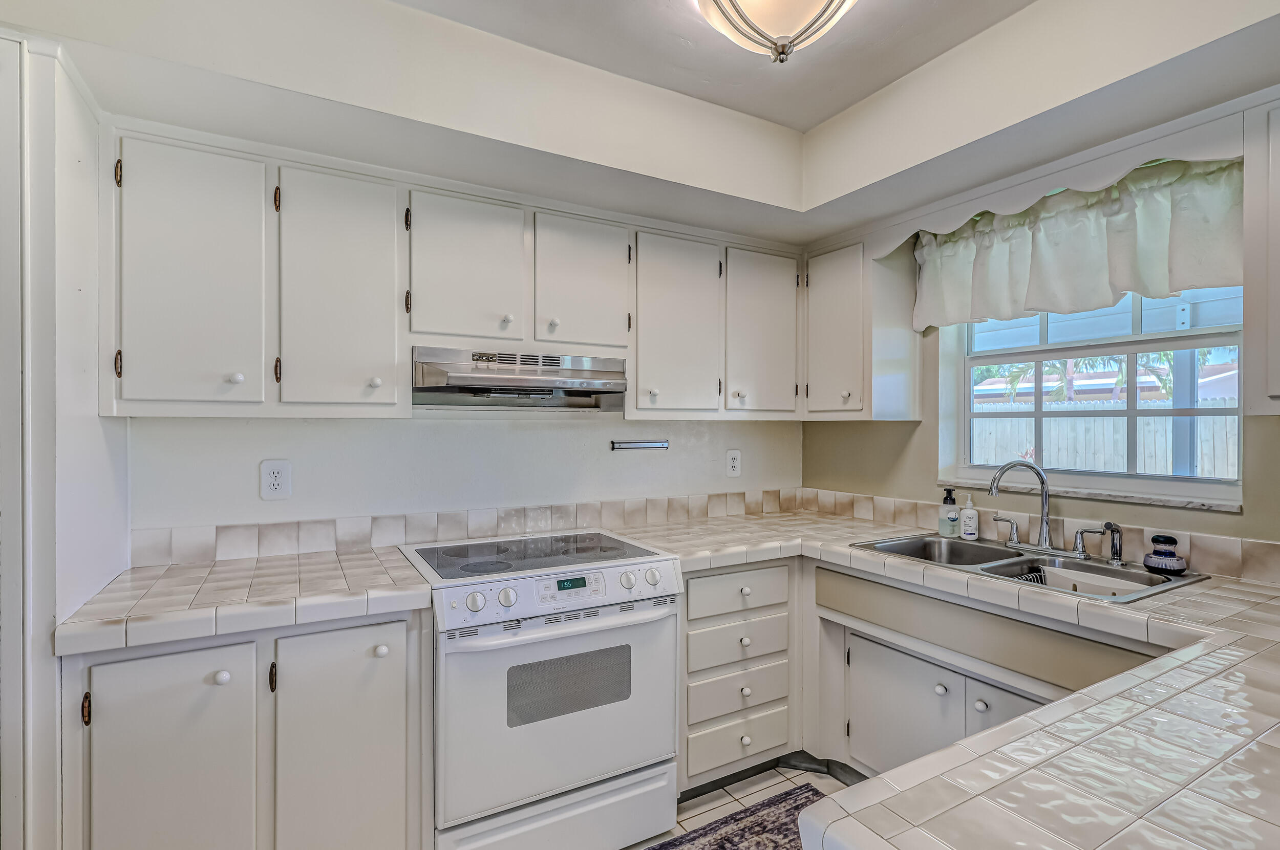 1618 Maypop Road West Palm Beach, FL 33415 - Photo 25 of 81 a kitchen with granite countertop white cabinets and white appliances