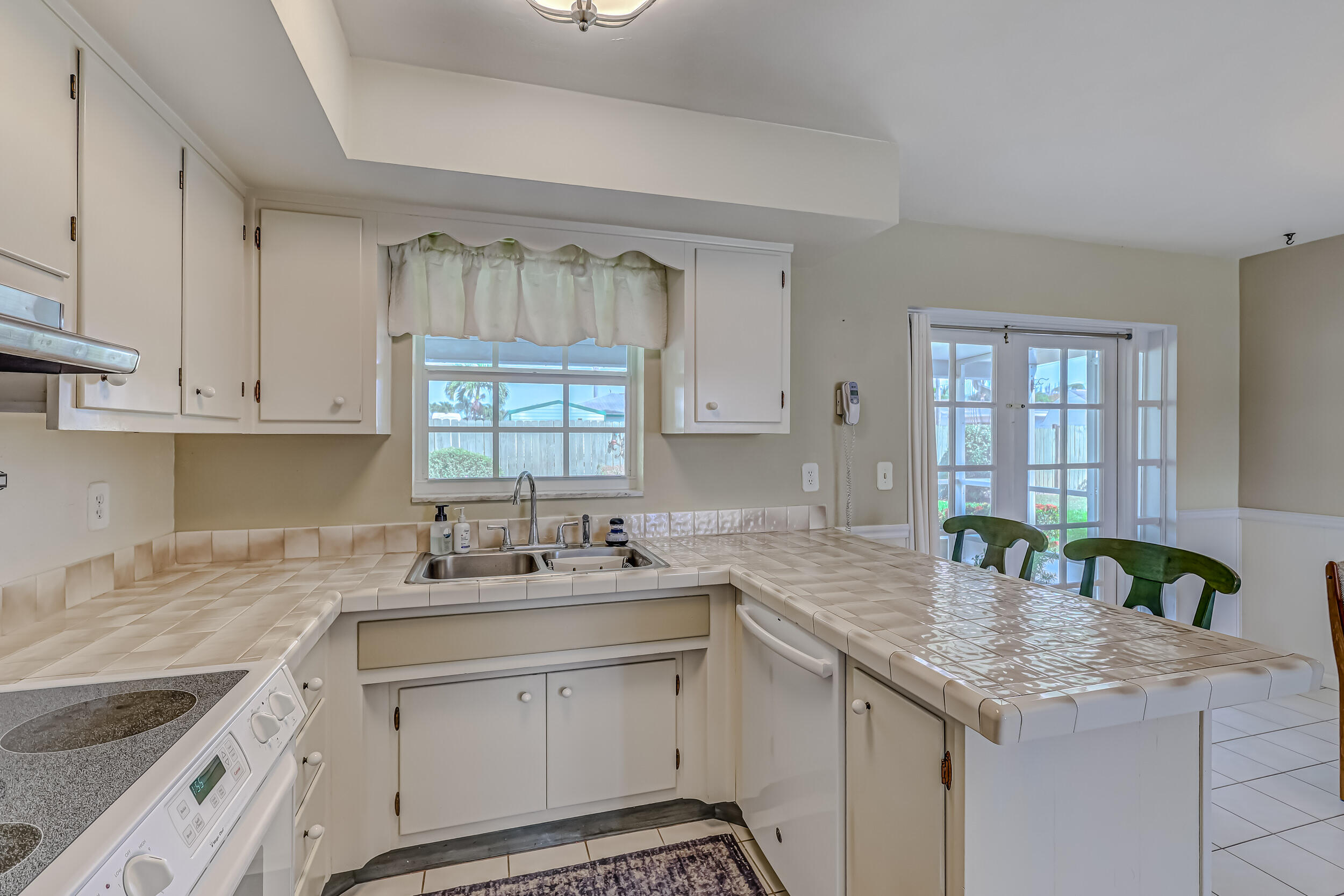 1618 Maypop Road West Palm Beach, FL 33415 - Photo 26 of 81 a kitchen with granite countertop a sink white cabinets and a window