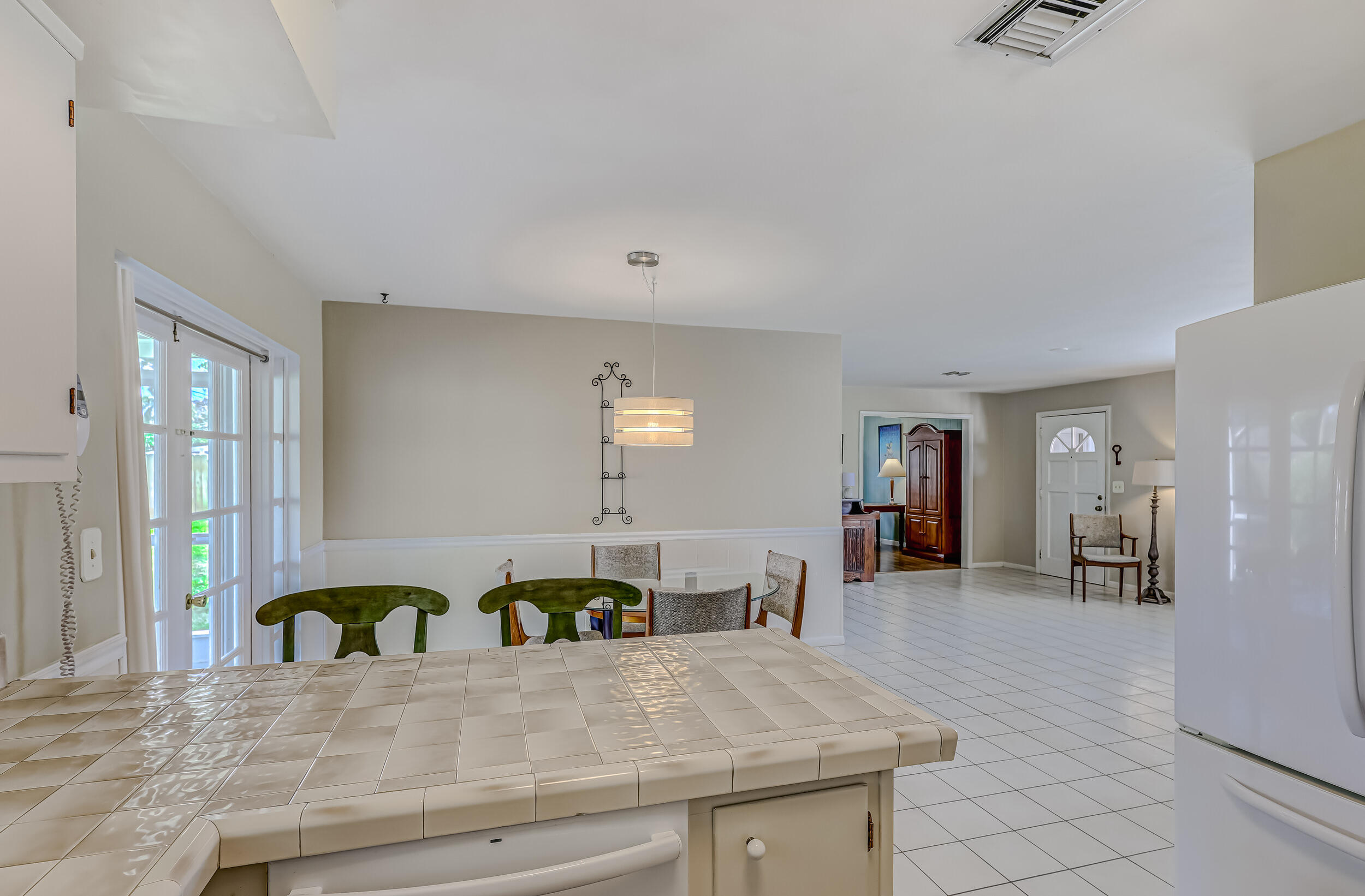 1618 Maypop Road West Palm Beach, FL 33415 - Photo 27 of 81 a kitchen with stainless steel appliances granite countertop a stove a sink a refrigerator white cabinets with dining table and chairs