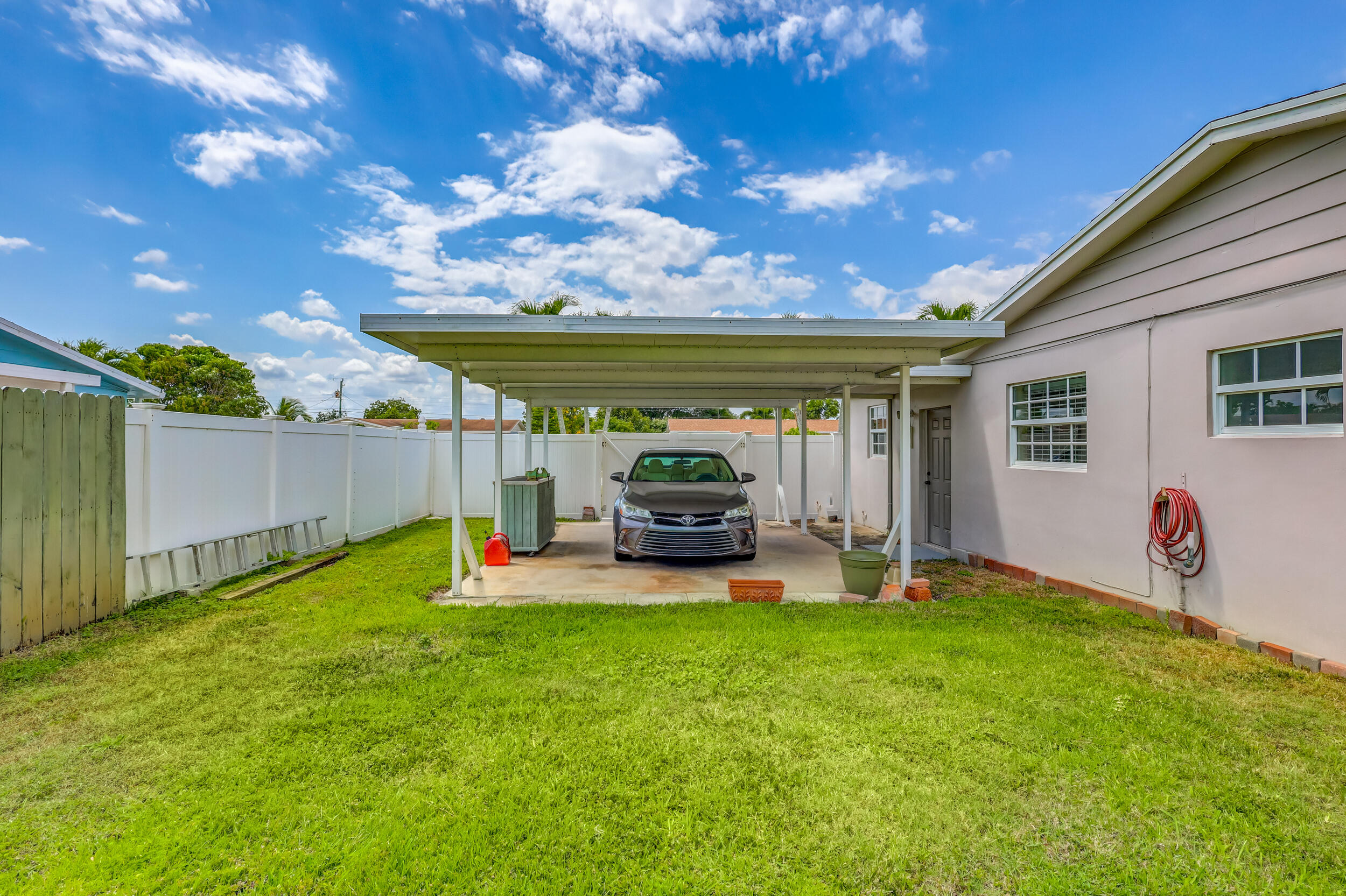 1618 Maypop Road West Palm Beach, FL 33415 - Photo 63 of 81 a view of a backyard with table and chairs and a barbeque with potted plants