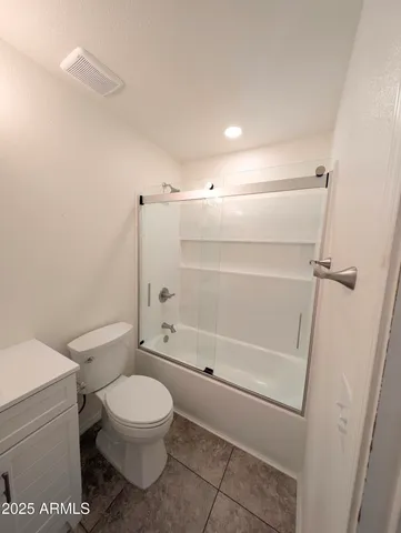 an empty room with wooden floor and fan