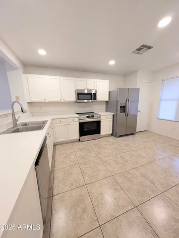 a large kitchen with stainless steel appliances granite countertop a stove a sink dishwasher and a refrigerator