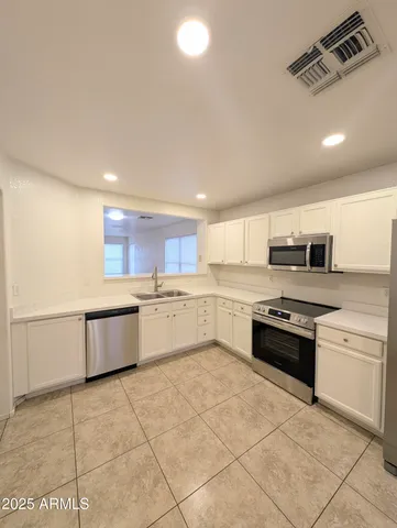 an empty room with wooden floor and chandelier fan