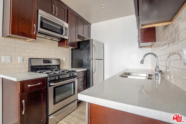 a kitchen with stainless steel appliances granite countertop a sink stove and microwave